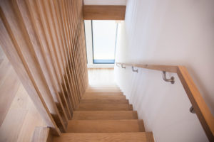 wooden staircase with wooden plank bannister