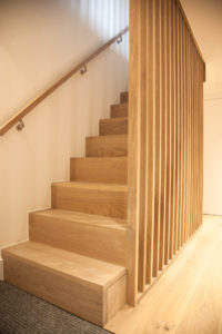 wooden staircase with wooden plank bannister