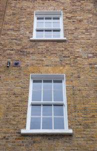 two windows on brick wall