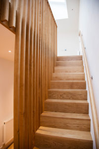 wooden staircase with wooden plank bannister