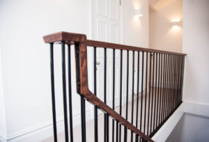 modern wooden staircase with metal plank bannister