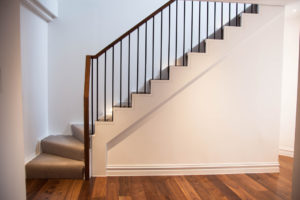 modern wooden staircase with metal plank bannister