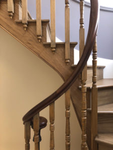 spiral wooden staircase with bannister , dark wood