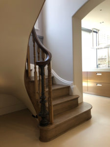 spiral wooden staircase with bannister , dark wood