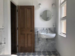 modern bathroom with marble wall and wooden door