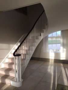 white open staircase with landing and black bannister