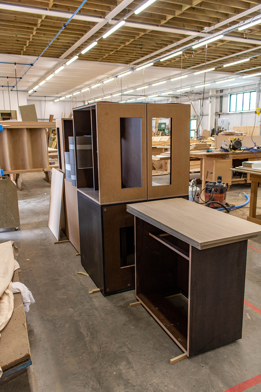 Set of dark brown wood cabinets in joinery workshop