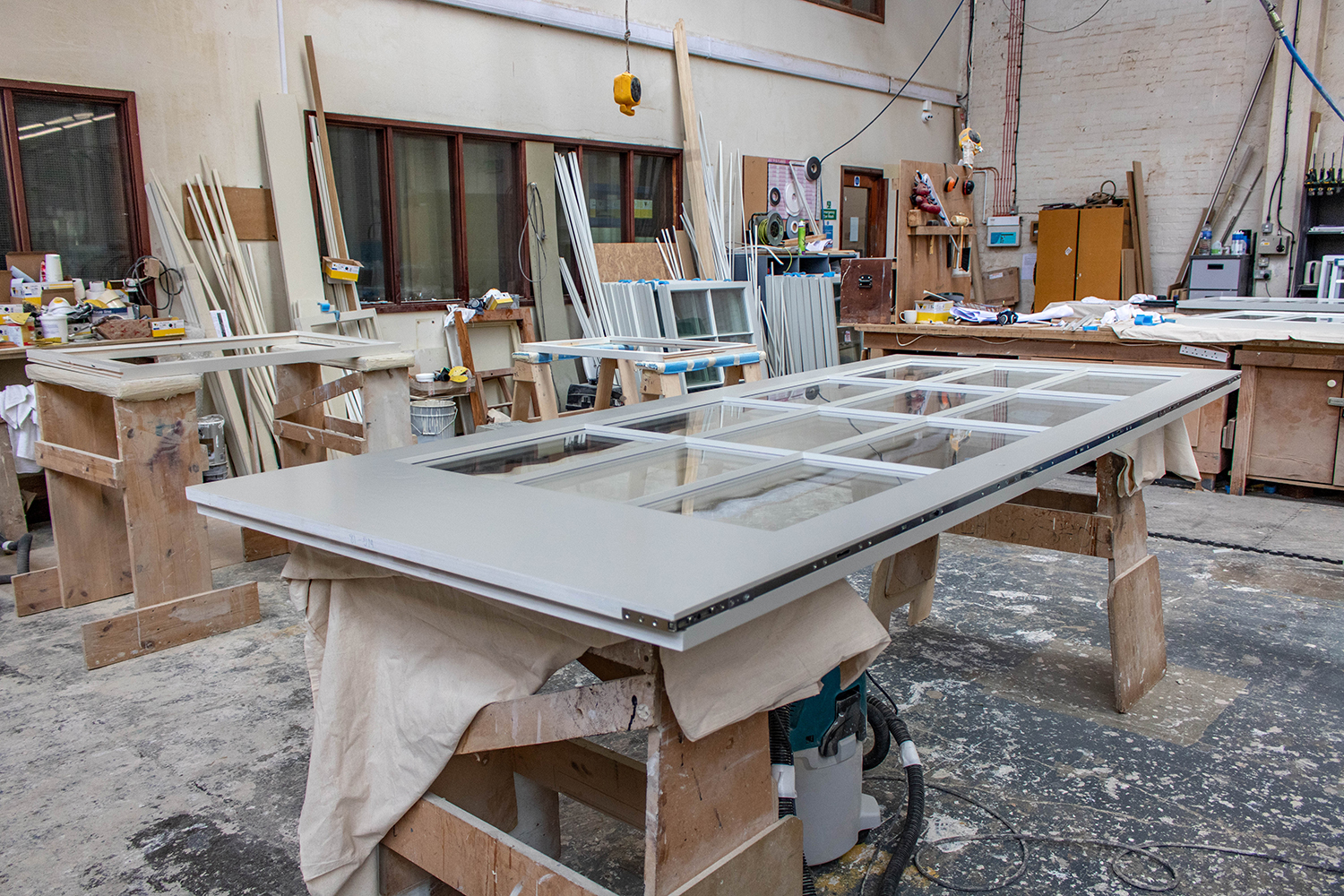 Large grey door with 12 glass panels in joinery workshop