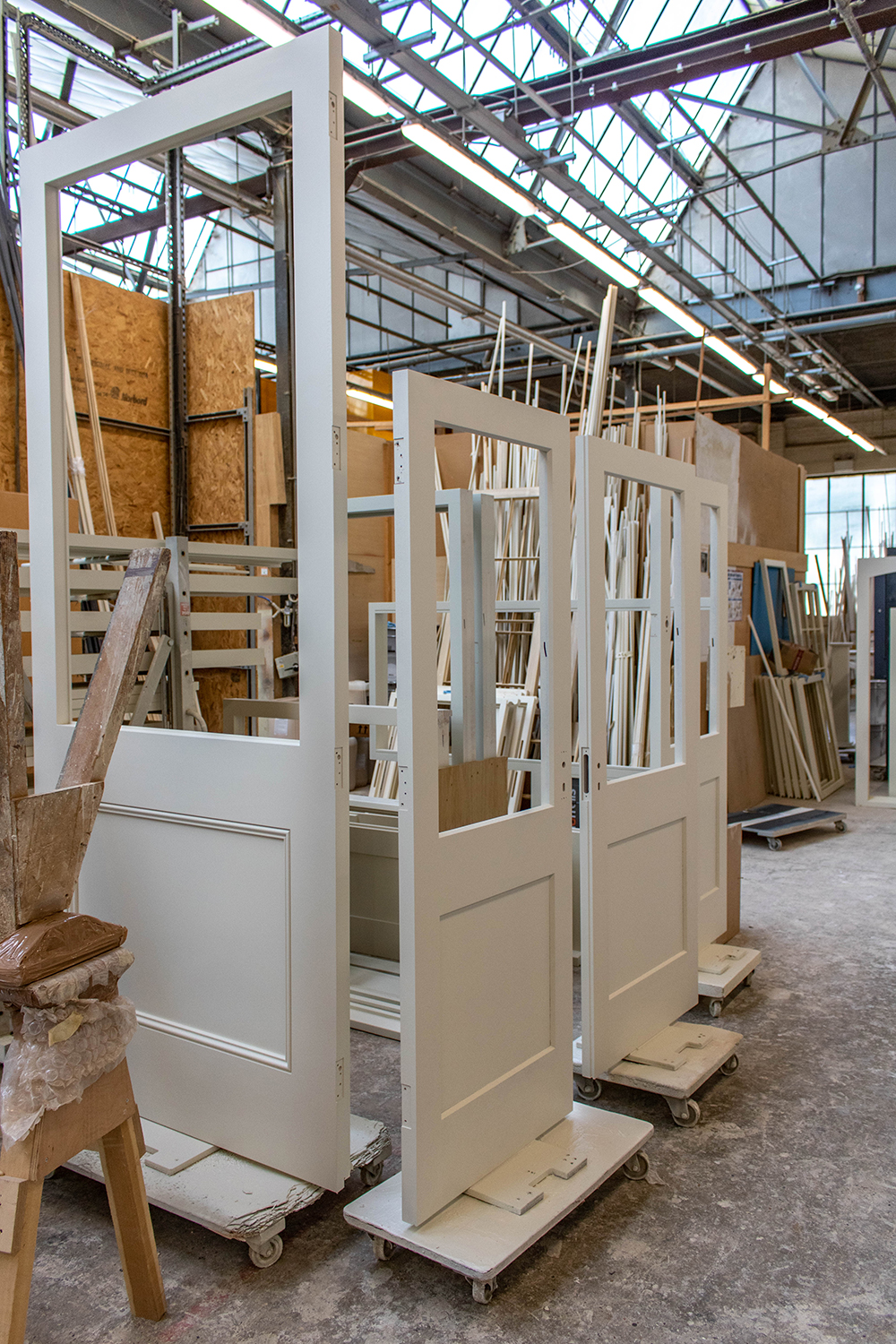 Set of white wooden door and side doors in joinery workshop